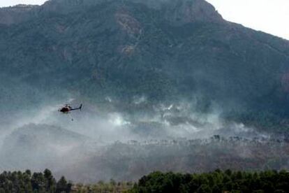 Unos doce medios aéreos (avionetas y helicópteros bombarderos) colaboran con la extinción del fuego en el Parque Natural de Els Ports