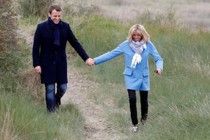 Emmanuel Macron y su esposa Brigitte Trogneux pasean por un campo de Le Touquet, en la víspera de la primera vuelta de las elecciones francesas, el 22 de abril de 2017.