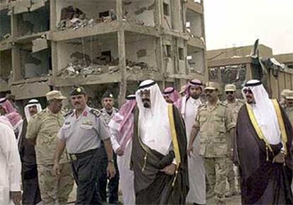 El príncipe Abdulá (en el centro) visita uno de los lugares donde estallaron los coches bomba.