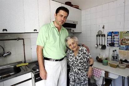 El voluntario Enrique Rodríguez y Esperanza Hernando, en la cocina de ella.