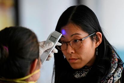 Personal sanitario revisa la temperatura de una pasajera, en el aeropuerto internacional de Guatemala, este miércoles.