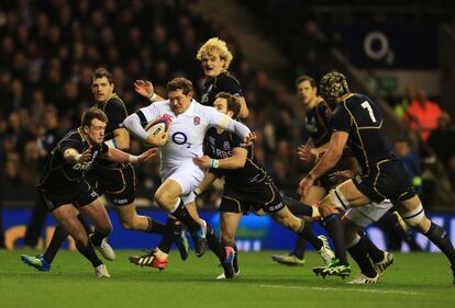 Alex Goode de Inglaterra es perseguido por la defensa escocesa.