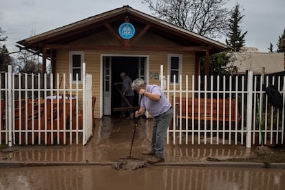 Dos hombres intentan sacar el agua y barro de una iglesia evangélica en Coltauco, el 26 de junio de 2023.