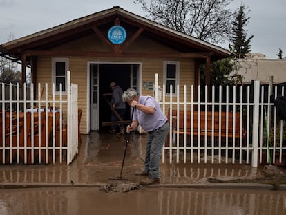Dos hombres limpian el barro que ha quedado dentro de una iglesia evangélica en Coltauco, en la Región de O'Higgins (Chile), el 26 de junio.