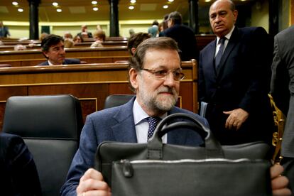 Mariano Rajoy (en primer término), con la cartera de presidente, en la sesión plenaria de control al Gobierno en el Congreso de los Diputados, y Jorge Fernández Díaz, ministro del Interior, en 2015.