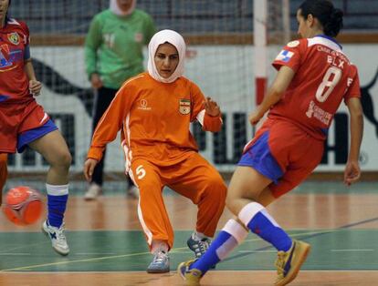 Una jugadora de de la selecci&oacute;n de f&uacute;tbol sala de Ir&aacute;n pelea un bal&oacute;n ante el equipo del Ocio Azul, de Elche.