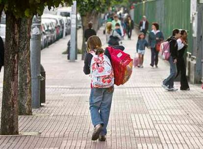 Una escolar carga dos mochilas en el inicio del curso escolar.