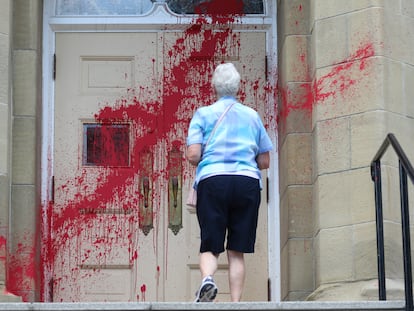 Uma fiel se aproxima da entrada da igreja presbiteriana Grace, atacada com tinta vermelha em Calgary, no dia 3.
