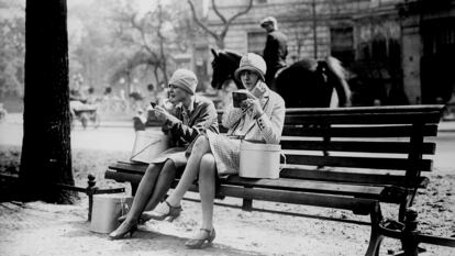 Unas mujeres se maquillan en un parque en París alrededor de 1930.