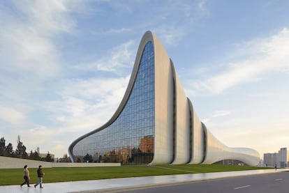 Con el centro cultural de Bakú, la arquitecta irakí Zaha Hadid, fallecida en 2016, ganó el premio de Diseño del Año 2014, concedido por el Design Museum de Londres. Hoy es uno de los símbolos del <a href="https://elviajero.elpais.com/elviajero/2019/08/01/actualidad/1564650691_005912.html" rel="nofollow" target="_blank">Bakú moderno</a>, con sus majestuosas curvas blancas. El centro Heydar Aliyev (<a href="http://heydaraliyevcenter.az" rel="nofollow" target="_blank">heydaraliyevcenter.az</a>) acoge un centro de congresos, un museo, salas de exposiciones y oficinas, pero sobre todo se ha convertido en icono de una ciudad deseosa de mostrar al mundo su modernidad. Delante del edificio, una plaza urbana amplía hacia el exterior el espacio de encuentro. Por dentro, las sinuosidades, las formas amplias, la integración entre interior y exterior y la sorprendente luminosidad son las claves del edificio. Fue precisamente la iluminación uno de los detalles más cuidados, pensada para crear dos edificios muy diferentes, por el día y por la noche. Durante el día, el volumen refleja la luz natural; cuando se pone el sol, se transforma poco a poco gracias a la proyección de la iluminación interna hacia las superficies exteriores, manteniendo ese fluido diálogo entre el interior y el exterior del edificio.