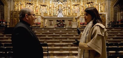 El deán de la catedral de Toledo, Juan Pedro Sánchez Gamero, y una de las presentadoras del programa, Leonor Martín, ante el altar mayor de la catedral.