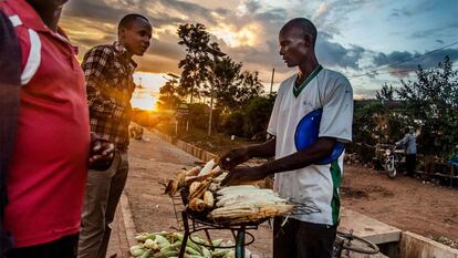 Un hombre vende maíz asado. Antes, Malaba era un pueblo pequeño, pero con los años, el aumento del comercio y el transporte lo han convertido en una próspera ciudad con multitud de pequeños negocios instalados junto a la carretera.