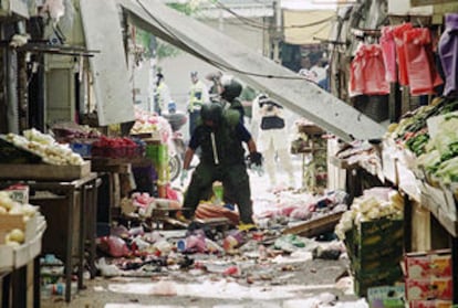 Dos policías revisan una zona del mercado afectado por el atendado suicida.