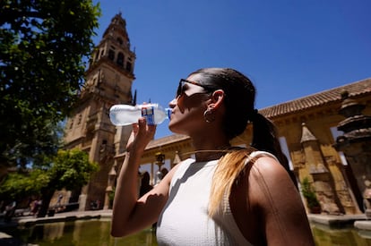 Una mujer bebe agua para refrescarse en el Patio de los Naranjos de Córdoba, el pasado viernes.