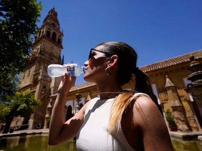 Una mujer bebe agua para refrescarse en el Patio de los Naranjos de Córdoba, el pasado viernes.