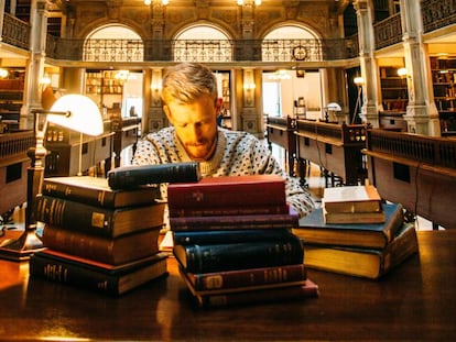 Un hombre estudia en una biblioteca.