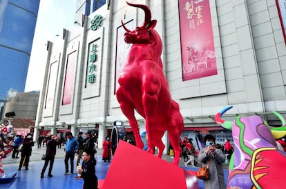 En 2021, el Año Nuevo chino, o Lunar, se celebra este viernes 12 de febrero según el calendario gregoriano (la noche del 11 equivale a la Nochevieja occidental). La llegada del Año del Buey se festeja no solo en China, donde es festivo entre el 11 y el 17 de febrero, también en otros países asiáticos y en los 'chinatowns' de grandes ciudades de todo el planeta. En muchas de ellas este año no habrá linternas, danzas de dragones, acróbatas o carrozas debido a la situación sanitaria. Pero el espíritu festivo se mantendrá intacto a la espera de tiempos mejores, gracias también a iniciativas 'online'. <br></br> Aunque con medidas de seguridad por la covid-19, y con el Templo de Dios de <a href="https://elviajero.elpais.com/elviajero/2020/07/23/actualidad/1595507528_236800.html" rel="nofollow" target="_blank">Shanghái</a>, en la parte vieja de la ciudad, cerrado para controlar la pandemia, los jardines de Yuyuan, que continúan abiertos (junto con los centros comerciales), se decoran con folclóricas y tradicionales linternas para vivir, el 26 de febrero, el Festival de las Linternas. Se notará la ausencia de turistas en la ciudad china, pero, a cambio, habrá más residentes debido a las restricciones a la movilidad impuestas por su Gobierno. Las creaciones luminosas de diferentes formas, tamaños y colores —desde peces, que representan riqueza y prosperidad, hasta dragones, que simbolizan la buena suerte, pasando, por supuesto, por bueyes— serán el colofón a las fiestas del Año Nuevo Lunar.<br></br> En la imagen, una escultura de un buey rojo con motivo del Año Nuevo chino en la zona comercial de Xujiahui, el pasado 19 de enero.