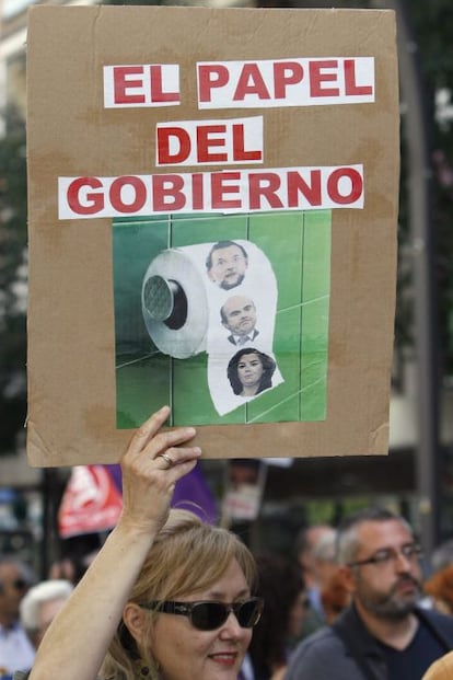 Una mujer muestra una pancarta contra el Gobierno, durante la manifestación que ha recorrido las calles de Murcia para celebrar el Primero de Mayo bajo el lema "Trabajo, Dignidad, Derechos" y contra la reforma laboral y los recortes del Ejecutivo de Mariano Rajoy.