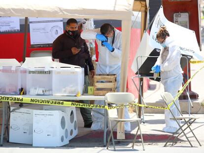 Peritos forenses trabajan en una casilla electoral en Tijuana donde un hombre arrojó una cabeza humana.
