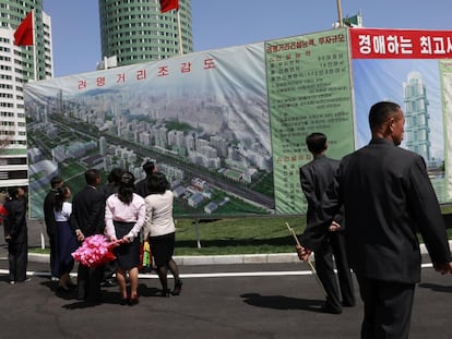 Ciudadanos norcoreanos observan, en una imagen de archivo, un cartel anunciador de un proyecto residencial en Pyonyang (Corea del Norte).