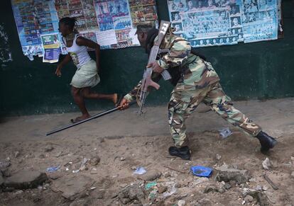 Un soldado persigue a uno de los manifestantes en el barrio de West Point (Monrovia). Una turba ha saqueado un centro de acogida instalado para presuntos casos de ébola, lo que ha facilitado la huida de 17 de los pacientes.