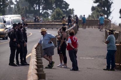 Agentes de la Policía Nacional y personal de Cruz Roja hablan con vecinos afectados por el corte de la carretera LP2 dirección Jedey, La Palma. 