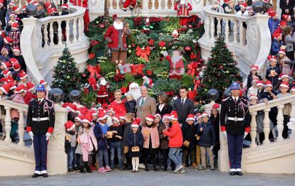 Los príncipes posan con los niños y Papa Noel tras la tradicional entrega de regalos navideños.