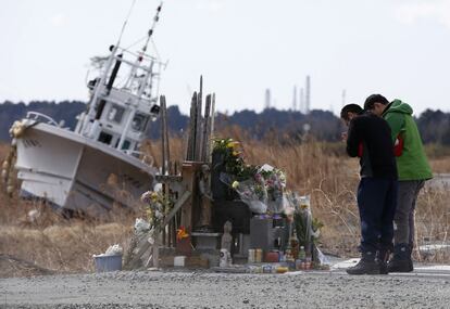 Dos personas rezan en Namie en el distrito de Fukushima (Jap&oacute;n) coincidiendo con el tercer aniversario del terremoto y tsunami, que dej&oacute; m&aacute;s de 18 mil muertos y desaparecidos, adem&aacute;s de provocar en el peor accidente nuclear del mundo desde el de Chernobyl. 