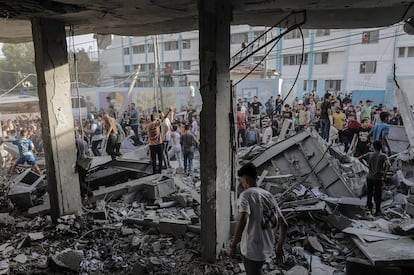 Un grupo de ciudadanos palestinos buscan cadáveres y supervivientes entre los escombros de un edificio derribado en un ataque aéreo en el sur de la franja de Gaza este sábado.