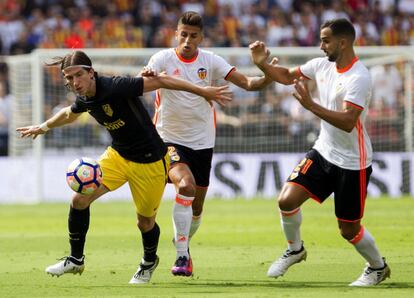 El defensa brasileño del Atlético de Madrid, Filipe Luis (i), controla el balón ante los jugadores del Valencia, el portugués Joao Cancelo (c), y Martín Montoya (d).