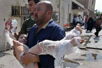 Un hombre llega al hospital Yarmuk de Bagdad llevando en brazos a un niño herido durante un ataque con proyectiles de mortero.