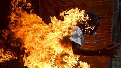 Jovem envolto em chamas durante o protesto.