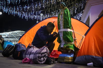 Un peregrino asegura una figura de la Virgen de Guadalupe a una casa de campaña para descansar antes de continuar su camino.