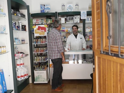 Francisco Aceituno atiende a un cliente en su farmacia de Villel de Mesa, Guadalajara el mi&eacute;rcoles pasado.