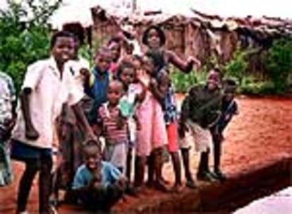 Un grupo de niños juegan junto a una charca en un poblado de las afueras de Maputo (Mozambique)