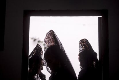 Varias mujeres con mantilla de la Hermandad de Nuestra Señora de la Esperanza y Cristo de Los Gitanos, del popular barrio de San Andrés de Córdoba, tras quedar suspendida esta tarde su estación de penitencia por razones meteorológicas.