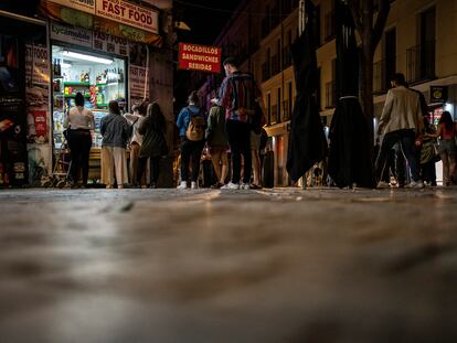 Jóvenes hacen cola para comprar en una tienda de Madrid, en la madrugada del 9 de mayo, tras acabar el estado de alarma.