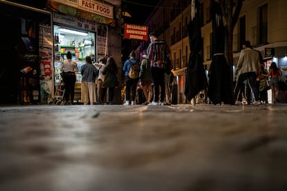 Jóvenes hacen cola para comprar en una tienda de Madrid, en la madrugada del 9 de mayo, tras acabar el estado de alarma.