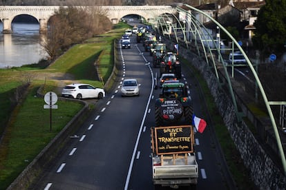 Los agricultores franceses marchan con sus tractores por la carretera. Uno de ellos (abajo) porta un cartel que dice "Ahorro y transmisión, código de honor del agricultor".