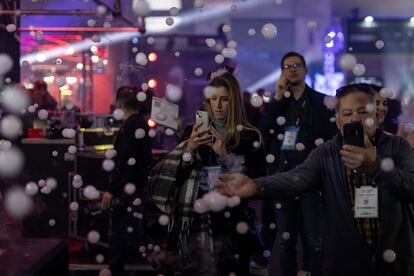 Asistentes al congreso ISE juegan con una máquina que genera burbujas rellenas de humo, este martes.