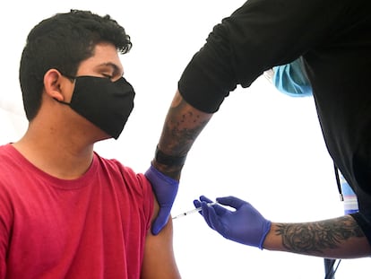 El estudiante Abraham Alvarado, de 17 años, recibe una dosis de la vacuna de Pfizer contra el coronavirus en un instituto de Los Ángeles.