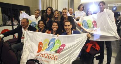 La delegación española muestra banderas de Madrid 2020 mientras siguen por pantalla gigante, en el Hotel NH de Buenos Aires, la presentación de la candidatura.