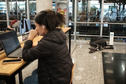 Mientras algunas personas trabajan desde sus computadores como en cualquier aeropuerto, en el Aeroparque se ven escenas como esta: una mujer labora a distancia mientras al fondo una persona se refugia del frío de la ciudad.