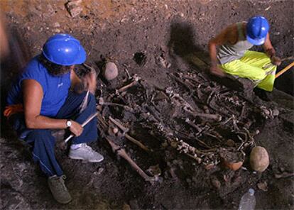 Dos operarios en las tareas de excavación de los restos encontrados en El Salvador.