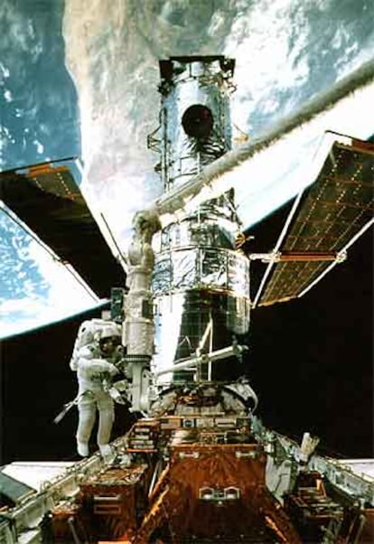 S. Smith revisa el <i>Hubble</i> en 1997. Al fondo, la Tierra.