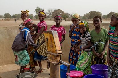 Unas niñas de Beleko juegan en la fuente instalada en el centro de su aldea. En ese círculo vicioso de carencias, los jardines de mujeres no son una solución infalible, pero estos y la mejora de otras infraestructuras como la mejora de la calidad del agua gracias a puntos de acceso limpios pueden acabar salvando más de una vida.
