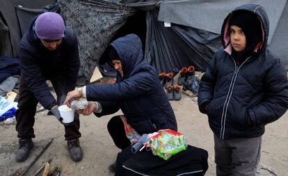 Migrantes junto a un fuego en un campamento cerca de Horgos (Serbia), en la frontera serbo-h&uacute;ngara, este lunes. 