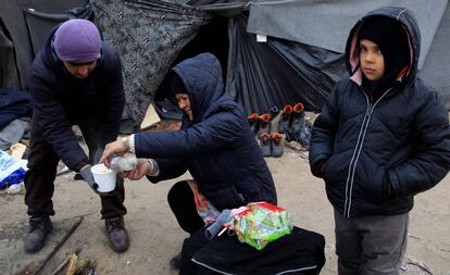 Migrantes junto a un fuego en un campamento cerca de Horgos (Serbia), en la frontera serbo-húngara, este lunes.