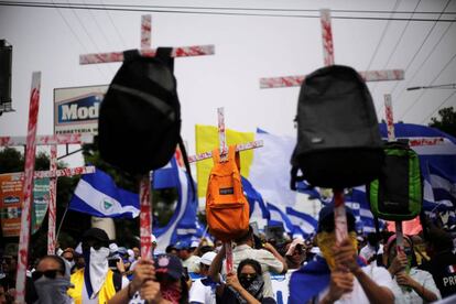 Los manifestantes sostienen cruces con mochilas durante una marcha para exigir el derrocamiento del presidente de Nicaragua, Daniel Ortega, en Managua.