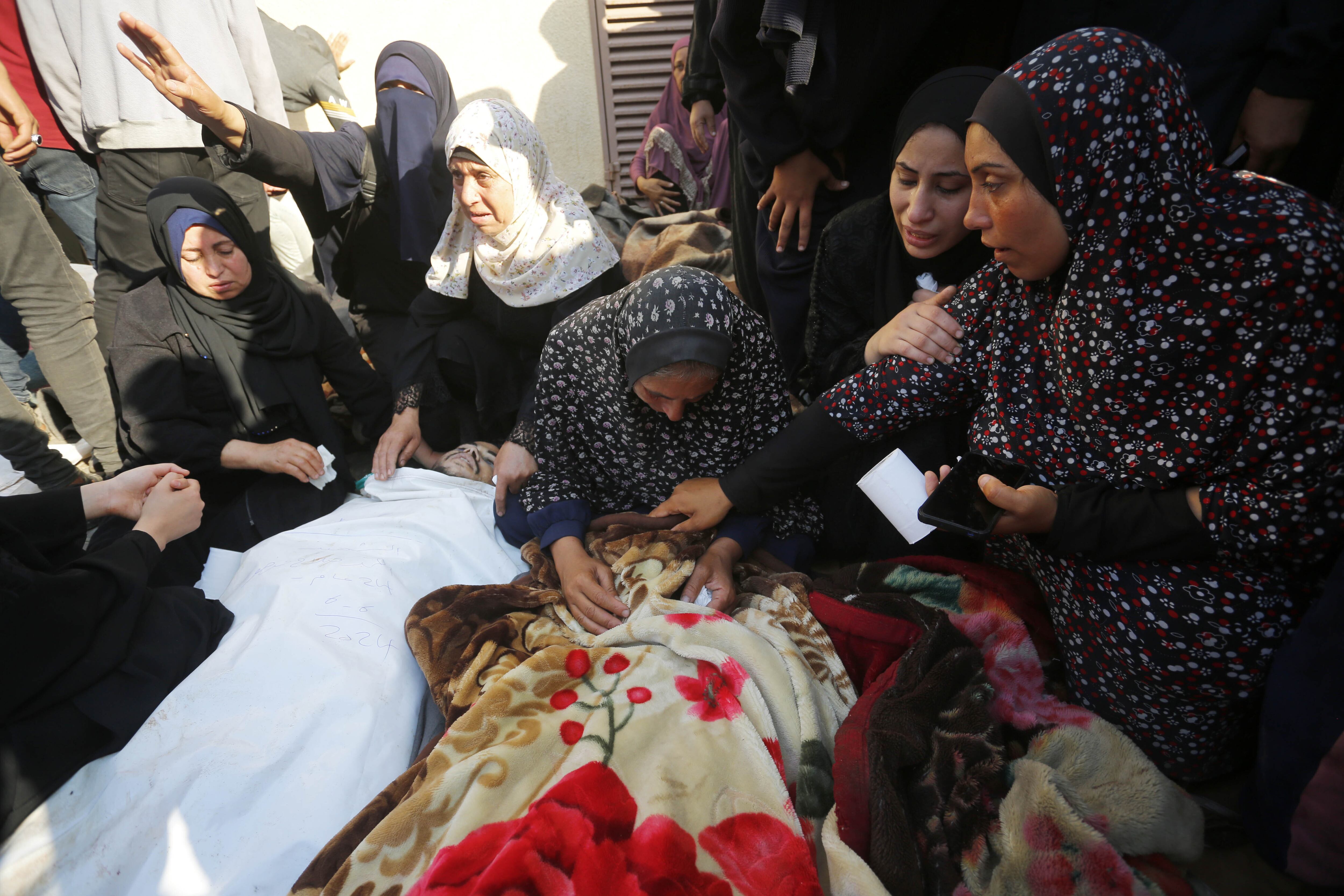 Palestinas lloran ante los cuerpos de sus familiares muertos en el ataque israelí en la UNRWA, en el Hospital de los Mártires de Al Aqsa, este jueves.  